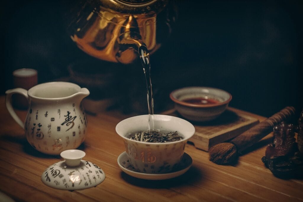 Artistic depiction of a traditional Chinese tea ceremony with porcelain teaware and hot water pour.